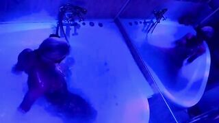 A blonde is having fun with a big toy in the bathroom