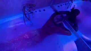 A blonde is having fun with a big toy in the bathroom