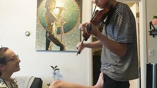 A couple was interrupted while the girl tried to practice violin