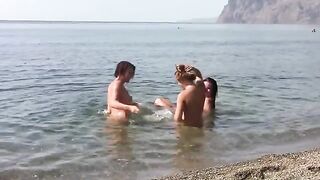 Three nudist girls have fun on the beach without any clothes