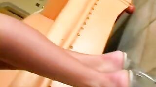 A beauty sits on a leather chair and caresses herself