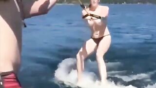 A sexy girl is water-skiing completely naked, her body glistening wet