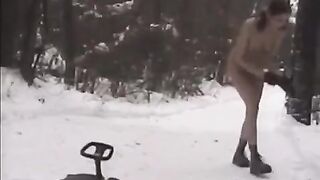 A hot naked girl is having fun with snowballs on the street