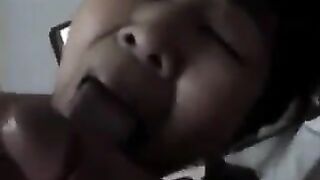 A Chinese woman practices her sucking dick skills on a guy in bed
