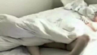 A girl rubs herself and a guy in the bedroom with a camera