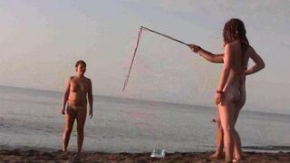 A naked girl is having fun on the beach, exposing her body in public
