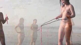 A naked girl is having fun on the beach, exposing her body in public