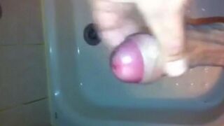 The kid masturbates his dick in the shower with his hand