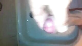 The kid masturbates his dick in the shower with his hand