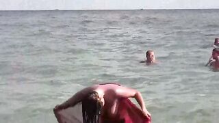A hot naked girl is having fun on the beach and masturbates