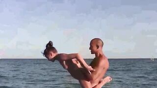 Acrobatic girls are completely naked on the beach
