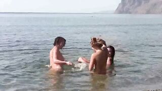 A group of nudists enjoy fun on the bare beach