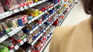 A girl is having fun with a guy, sitting on a bottle in the grocery store