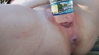A woman reaches a peak of pleasure while masturbating outdoors